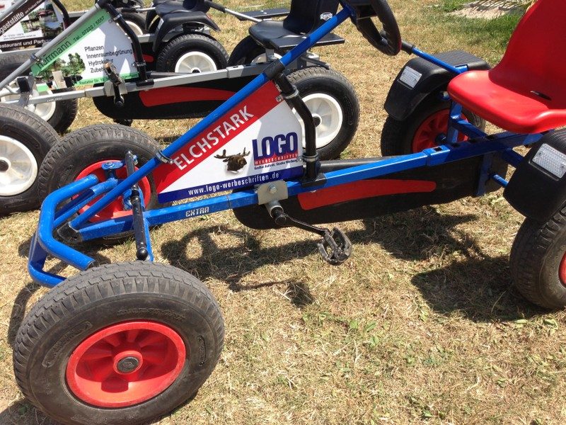 Blaues Kart mit Werbeschild eines Werbetechnik-Betriebs